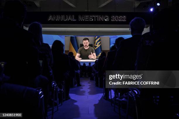 Ukrainian President Volodymyr Zelensky is seen on a giant screen during his address by video conference as part of the World Economic Forum annual...