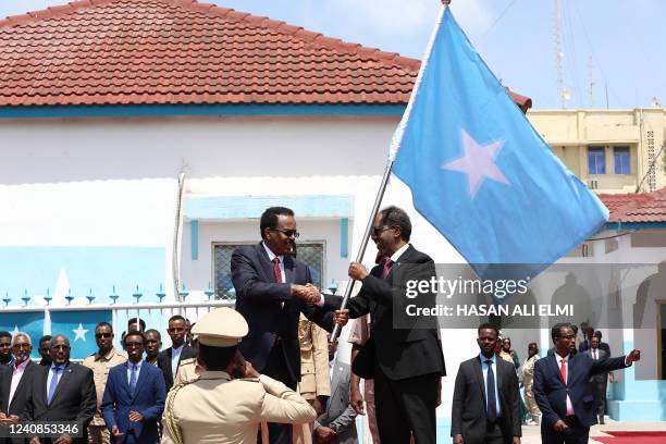 Outgoing Somalia President Mohamed Abdullahi Mohamed , also known as Farmaajo, presents the Somali flag to newly elected President Hassan Sheikh...