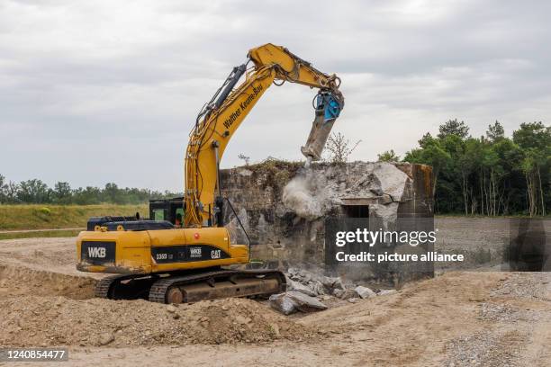 May 2022, Baden-Wuerttemberg, Breisach: An excavator destroys a World War II bunker with a hydraulic chisel. The World War II bunker must make way...