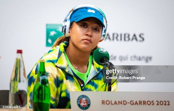 Naomi Osaka of Japan talks to the media after losing to Amanda Anisimova of the United States in her first round match on Day 2 at Roland Garros on...