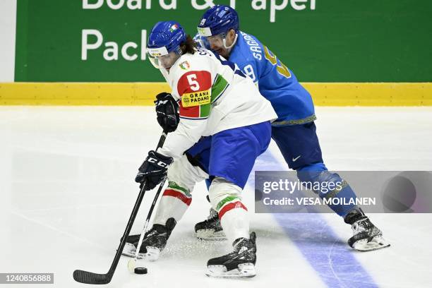 Italy's forward Marco Sanna and Kazakhstan's forward Anton Sagadeyev Sagadayev vie during the 2022 IIHF Ice Hockey World Championships preliminary...