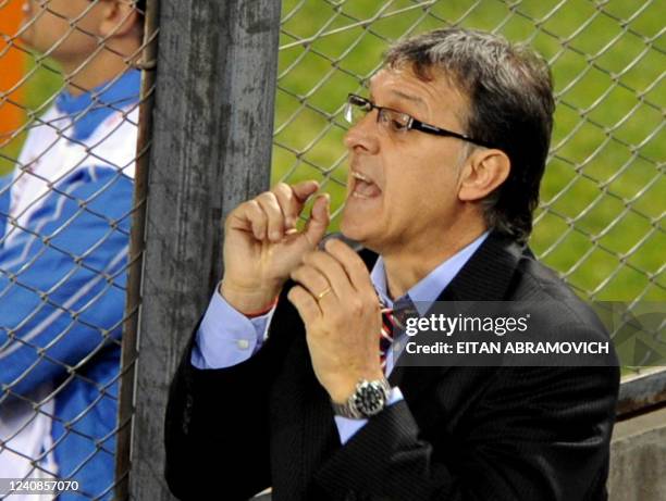 Paraguay's head coach Gerardo Martino gives instructions to his players from behind a fence, during the 2011 Copa America Group B first round...