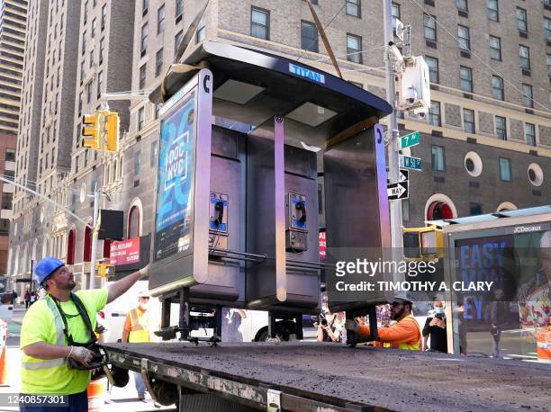 Workers remove the final New York City payphone near Seventh Avenue and 49th Street in Midtown Manhattan, New York City, on May 23, 2022. - Marking...