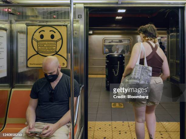 Sign notifies commuters to wear a mask inside a subway in New York, US, on Sunday, May 22, 2022. New York City has raised its Covid-19 alert level to...
