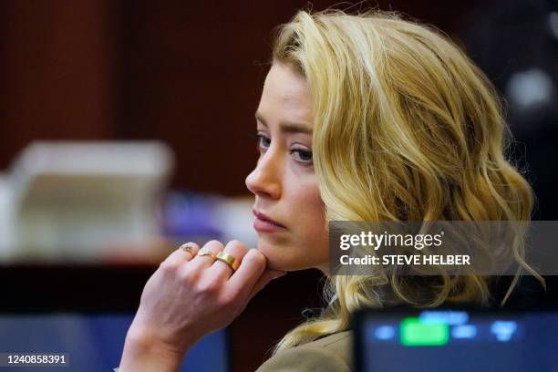 Actor Amber Heard listens in the courtroom at the Fairfax County Circuit Courthouse in Fairfax, Virginia, on May 23, 2022. - US actor Johnny Depp...