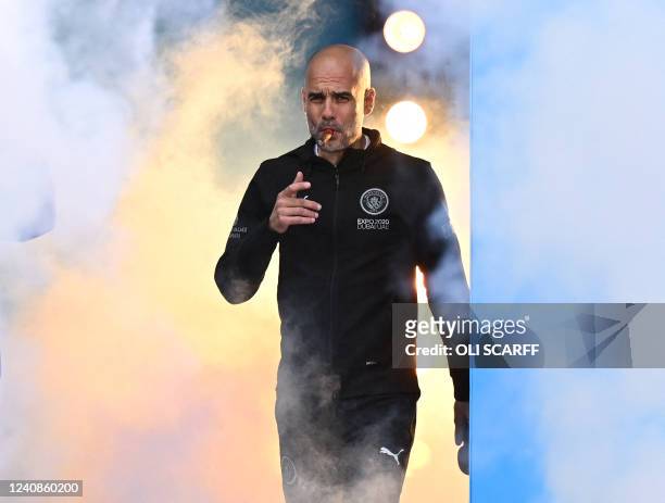 Manchester City's Spanish manager Pep Guardiola smokes a cigar as he attends an event for fans with members of the Manchester City football team...