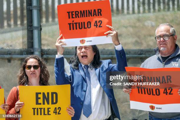 Immigration rights advocates stand at the US-Mexico border wall during a protest against Title 42 in San Ysidro, California, on May 23, 2022. - A...