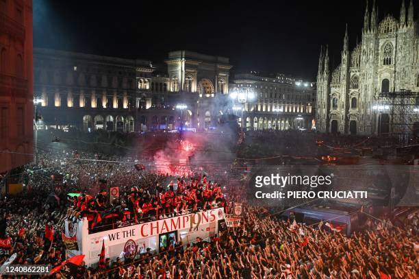 Supporters cheer as AC Milan players parade with the Scudetto Trophy on a double decker bus at Piazza Duomo in Milan, on May 23, 2022 one day after...