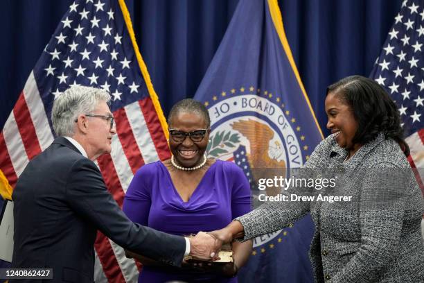 Chair of the Federal Reserve Jerome Powell shakes hands with Lisa Cook, after she took the oath of office to serve as a member of the Board of...