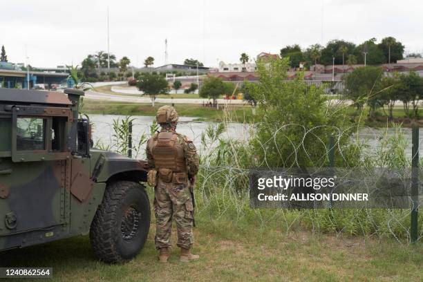 National Guard soldier stands by as Texas Governor Greg Abbott tours the US-Mexico border at the Rio Grande River in Eagle Pass, Texas, on May 23,...