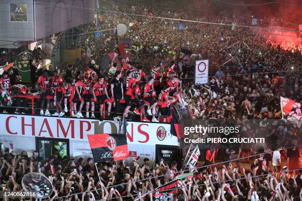 Supporters cheer as AC Milan players parade with the Scudetto Trophy on a double decker bus at Piazza Duomo in Milan, on May 23, 2022 one day after...