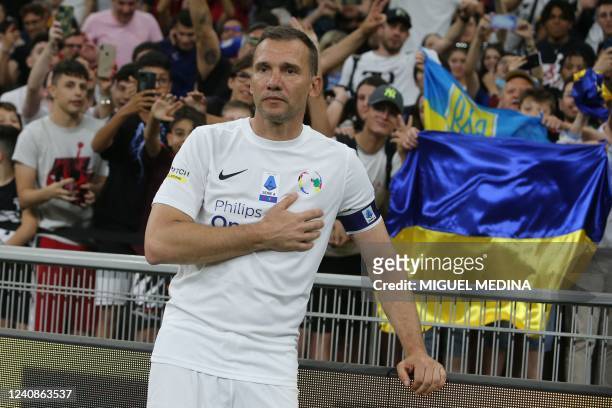 Former Ukranian forward Andriy Shevchenko poses next to the Ukainian flag after the exhibition football match "Integration Heroes" between United...