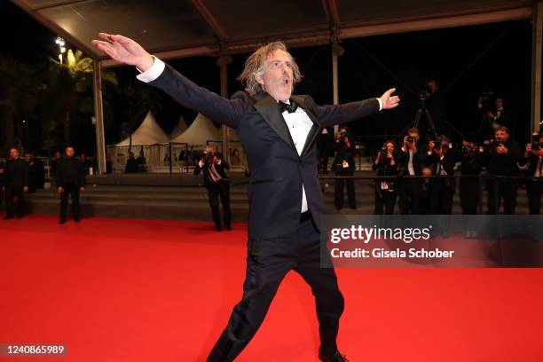 Director Brett Morgen dances the carpet during the screening of "Moonage Daydream" during the 75th annual Cannes film festival at Palais des...