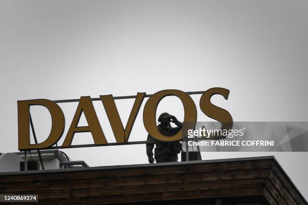 Speciale police officer is seen on the roof of the Congress hotel during a session at the World Economic Forum annual meeting in Davos on May 24,...