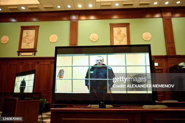 Opposition leader Alexei Navalny appears on a screen set up at a courtroom of the Moscow City Court via a video link from his prison colony during a...