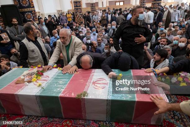 Iranian men mourn next to the coffin containing the body of the Islamic Revolutionary Guard Corps' colonel, Sayyad Khodai, during Khodais funeral in...