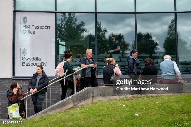 People queue outside the Newport HM Passport Office on May 24, 2022 in Newport, Wales. There has been a surge in demand for passport applications as...