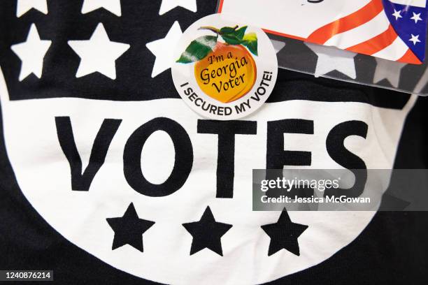 Poll worker wears an "I'm a Georgia Voter" sticker at the Metropolitan Library polling location on May 24, 2022 in Atlanta, Georgia. Voters across...