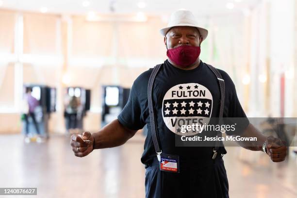 Poll worker Kelvin Ellis greets voters as they enter the Park Tavern polling location to cast their ballots in the Georgia primary election on May...