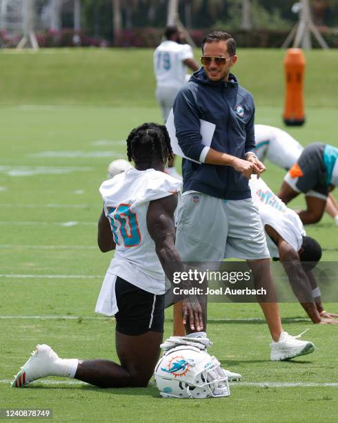 Head coach Mike McDaniel talks to Tyreek Hill of the Miami Dolphins during the teams OTAs at the Baptist Health Training Complex on May 24, 2022 in...