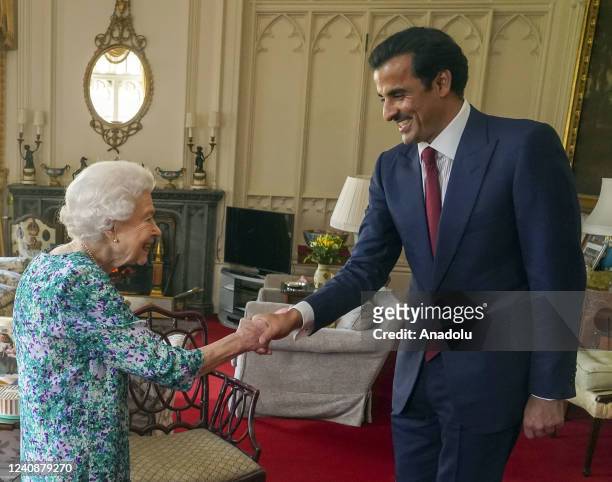 Britain's Queen Elizabeth II shakes hands with the Emir of Qatar Sheikh Tamim bin Hamad Al-Thani during a visit at Windsor Castle in London, United...