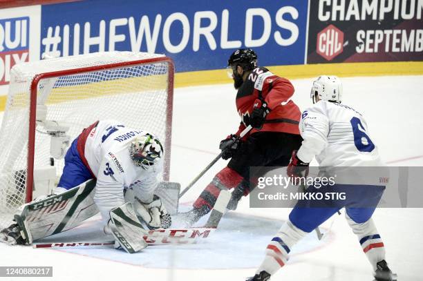 Canada's forward Eric O'Dell scores his team's fourth goal against France's goalkeeper Sebastian Ylonen and France's defender Vincent Llorca during...