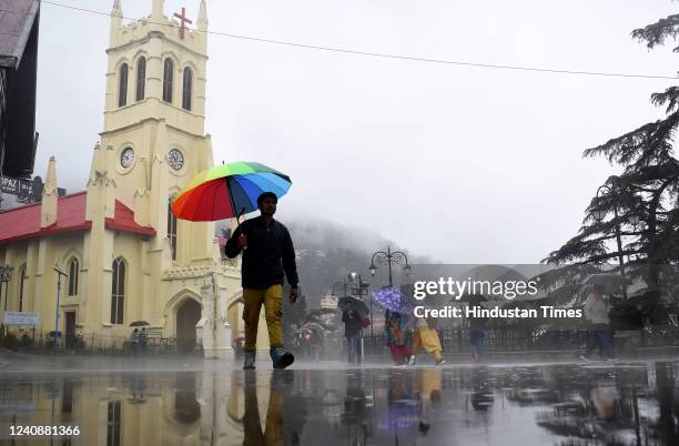 Tourists and locals out in the rain at Ridge, on May 24, 2022 in Shimla, India.