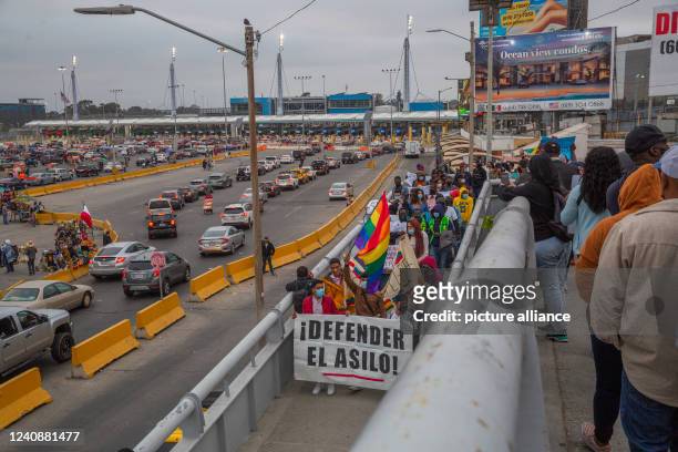 May 2022, Mexico, Tijuana: "Stand for asylum," reads the placard migrants hold up at a rally at the San Ysidro border crossing against the so-called...