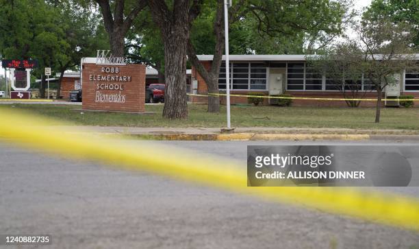 Sheriff crime scene tape is seen outside of Robb Elementary School as State troopers guard the area in Uvalde, Texas, on May 24, 2022. - An...