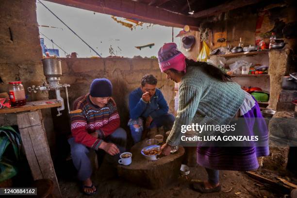 Saul Luciano Lliuya his son Brandon and his wife Lidia eat at their farm, in Huaraz, northeastern Peru, on May 24, 2022. - Lliuya, a farmer and...