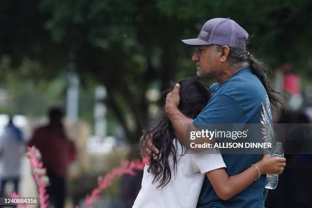 Families hug outside the Willie de Leon Civic Center where grief counseling will be offered in Uvalde, Texas, on May 24, 2022. - A teenage gunman...
