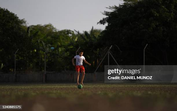 Boy plays soccer on a dusty field in Barrancas, Guajira province, Colombia, on May 22, 2022. - With bare feet on dusty fields, an indigenous man who...