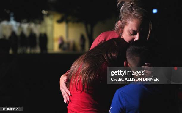 Families hug outside the Willie de Leon Civic Center where grief counseling will be offered in Uvalde, Texas, on May 24, 2022. - A teenage gunman...