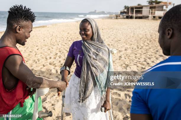 Woman greets members of a Single Leg Amputee Sports Association football team in Freetown on April 16, 2022. - The Single Leg Amputee Sports...