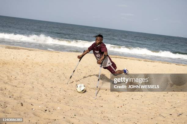 Member of a Single Leg Amputee Sports Association football team kicks the ball during training session in Freetown on April 16, 2022. - The Single...