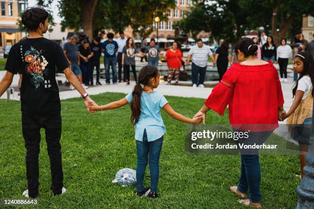 Members of the community gather at the City of Uvalde Town Square for a prayer vigil in the wake of a mass shooting at Robb Elementary School on May...