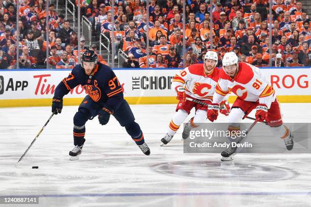 Connor McDavid of the Edmonton Oilers skates past Calle Jarnkrok and Blake Coleman of the Calgary Flames during Game Four of the Second Round of the...