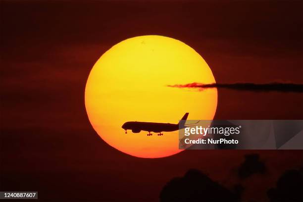 Commercial airplane makes a descend towards Changi International Airport as the sun rises on May 25, 2022 in Singapore.