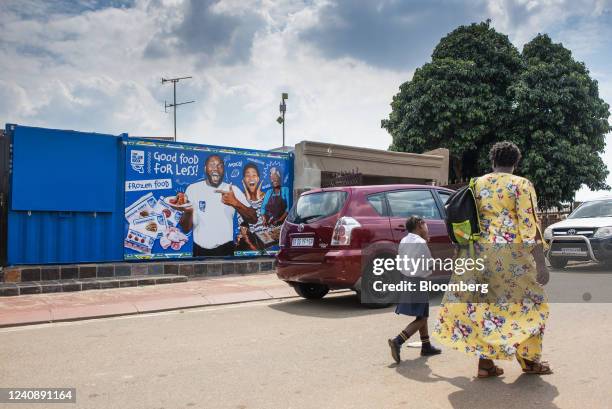 Mother and child pass a Blue Box frozen food advertisement in the Soweto district of Johannesburg, South Africa, on Wednesday, March 4, 2020. South...