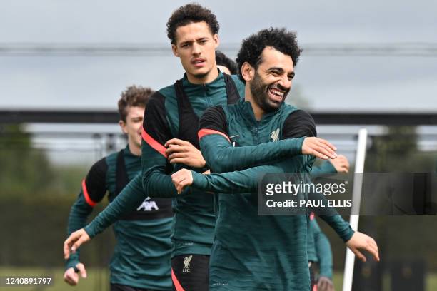 Liverpool's Egyptian midfielder Mohamed Salah laughs as he runs with teammates during a training session at their training ground in Liverpool,...