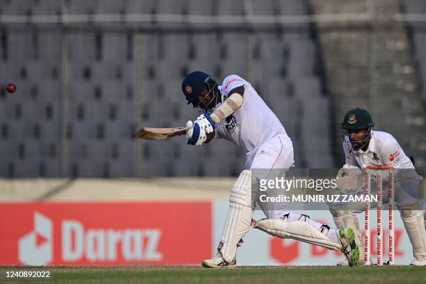 Sri Lanka's Angelo Mathews plays a shot as Bangladesh's wicketkeeper Liton Das watches during the third day of the second Test cricket match between...