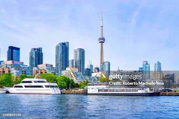 Urban skyline and cityscape during the daytime. The images includes yachts moored in Lake Ontario and the CN Tower.