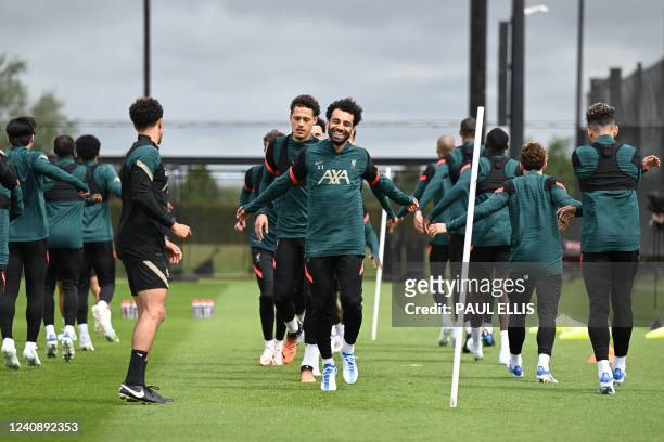 Liverpool's Egyptian midfielder Mohamed Salah laughs as he runs during a training session at their training ground in Liverpool, northwest England,...