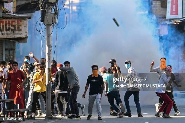 Protestors take part in a demonstration amid tear gas smoke fired by Indian security forces to disperse them in Srinagar on May 25 over the...