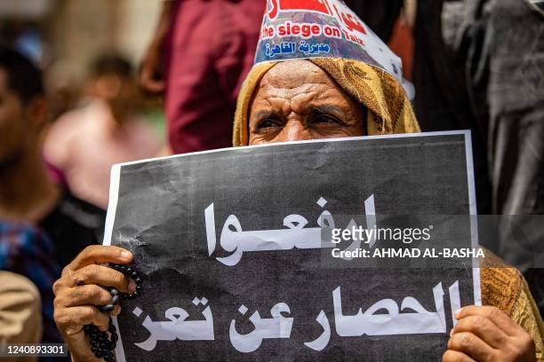 Demonstrator holds a sign reading in Arabic "end the siege on Taez" demanding the end of a years-long blockade of the area imposed by Yemen's Huthi...