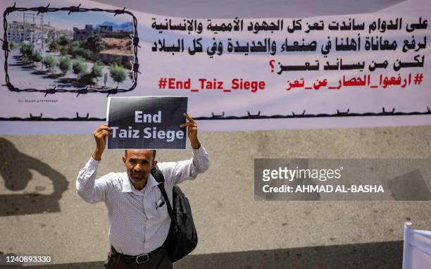 Demonstrator holds a sign reading in English "end Taiz [Taez] siege" demanding the end of a years-long blockade of the area imposed by Yemen's Huthi...