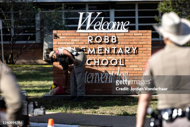 Texas State Trooper receives flowers for the victims of a mass shooting yesterday at Robb Elementary School where 21 people were killed, including 19...