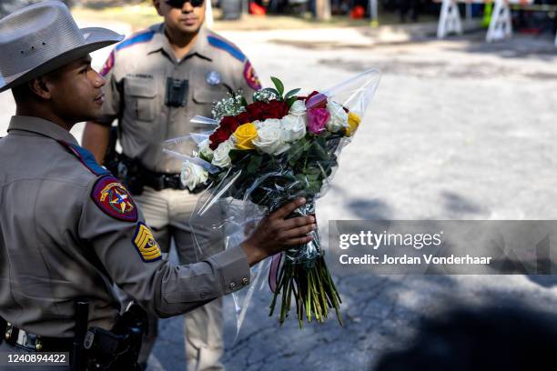 Texas State Trooper receives flowers for the victims of a mass shooting yesterday at Robb Elementary School where 21 people were killed, including 19...