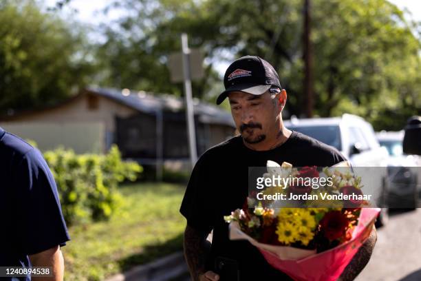 Joshua Dominguez from San Antonio, Texas brings flowers to Robb Elementary School after a mass shooting yesterday where 21 people were killed,...
