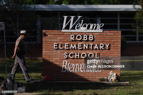 An officer walks outside of Robb Elementary School in Uvalde, Texas, on May 25, 2022. - A tight-knit Latino community in Texas was wracked with grief...